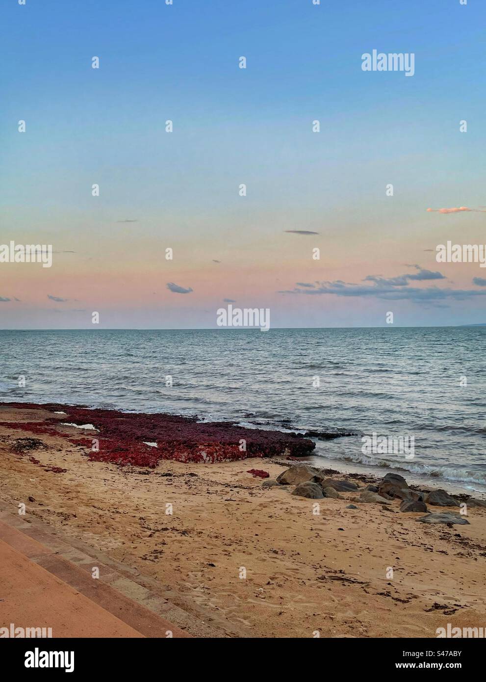 Sunset and red rocks at the beach Stock Photo Alamy