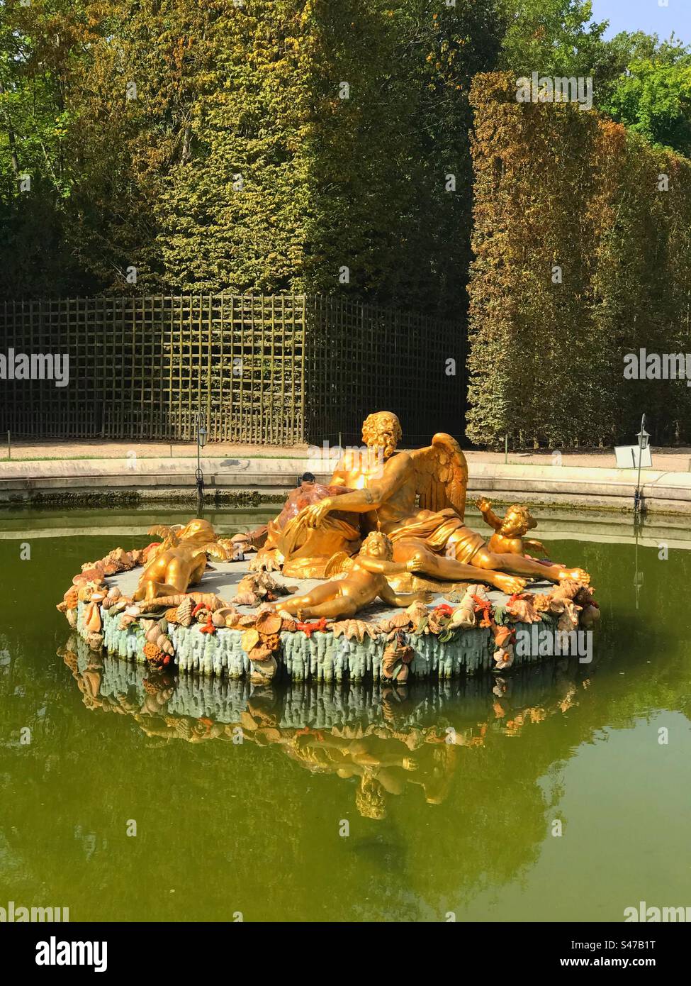 A golden fountain/statue in the gardens of the Palace of Versailles - Smartphone Captured Stock Image