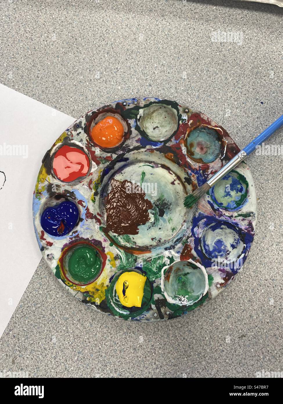 A palette with different coloured paints and a beuah. - Smartphone Captured Stock Image