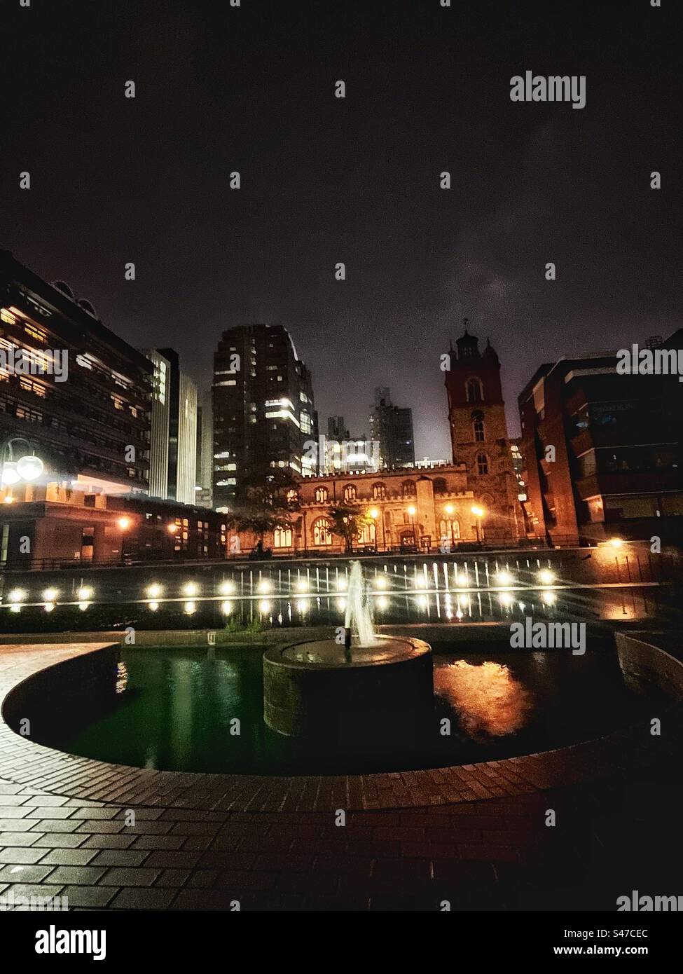 St Giles' Cripplegate in the heart of the Barbican estate - a medieval church within a brutalist architectural complex of housing and cultural institutions seen at night - Smartphone Captured Stock Image