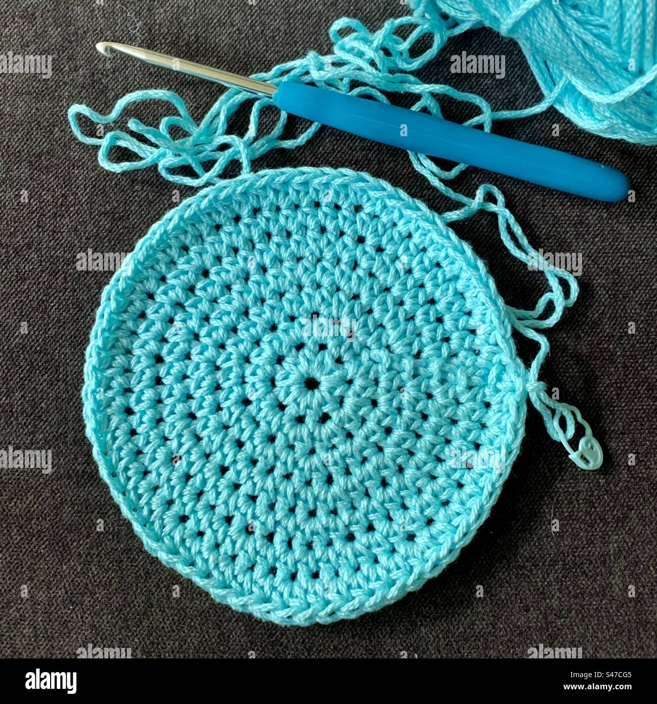 Crocheted circle, yarn and hook. Stock Photo