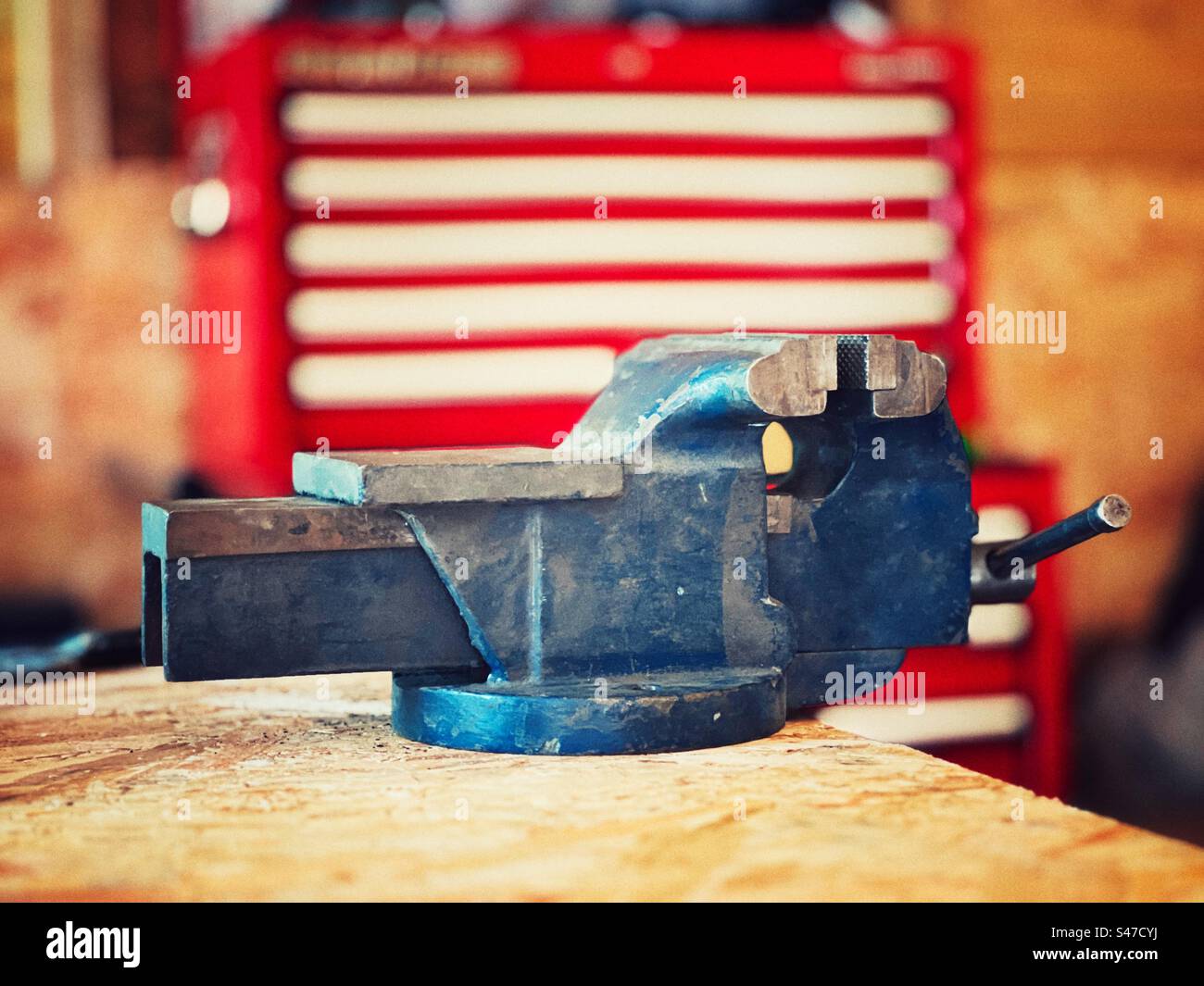Vintage engineers metalworking vice against red and white background - Smartphone Captured Stock Image