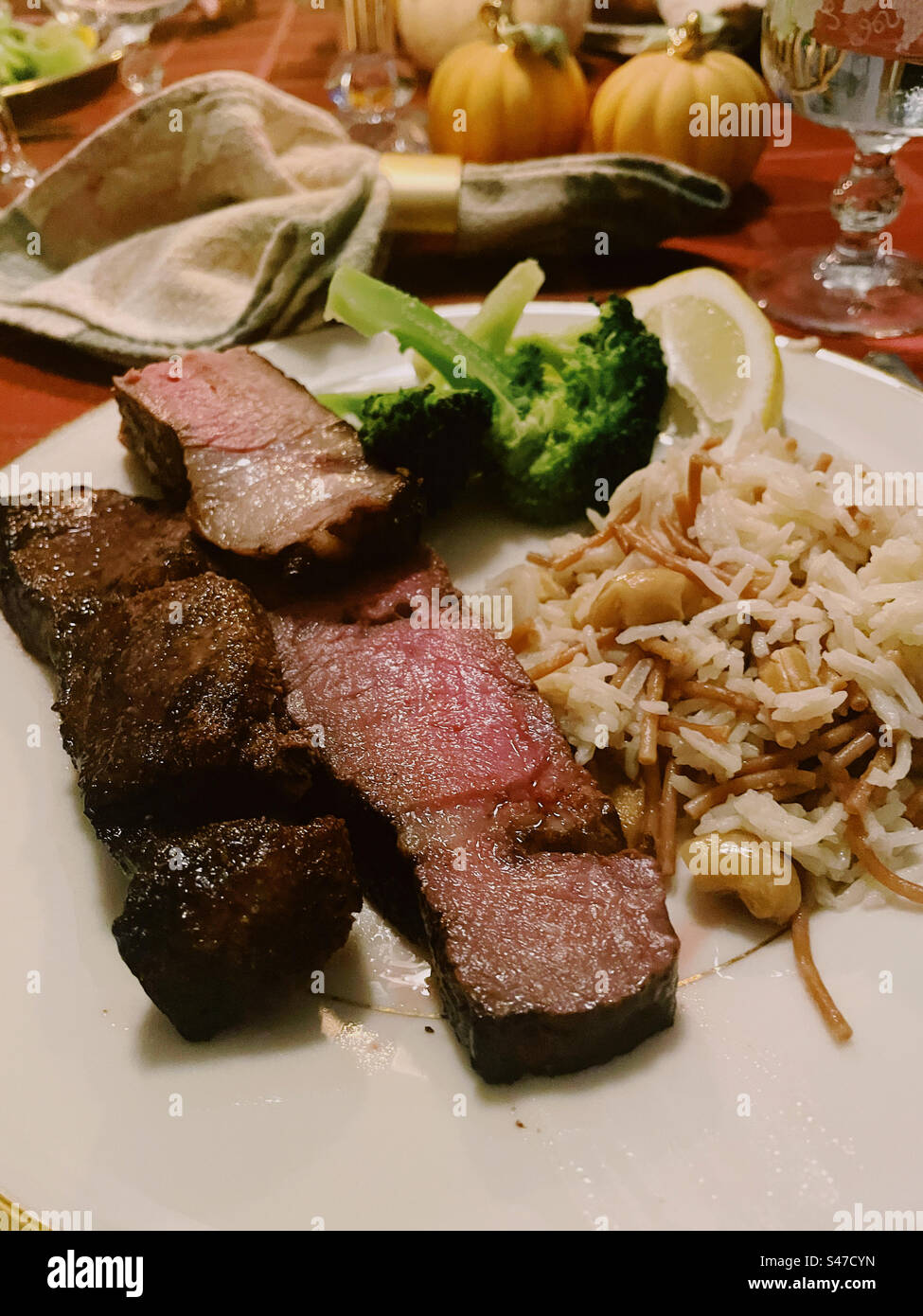 Close up of a steak dinner on a residential dining room table, 2023, United States - Smartphone Captured Stock Image