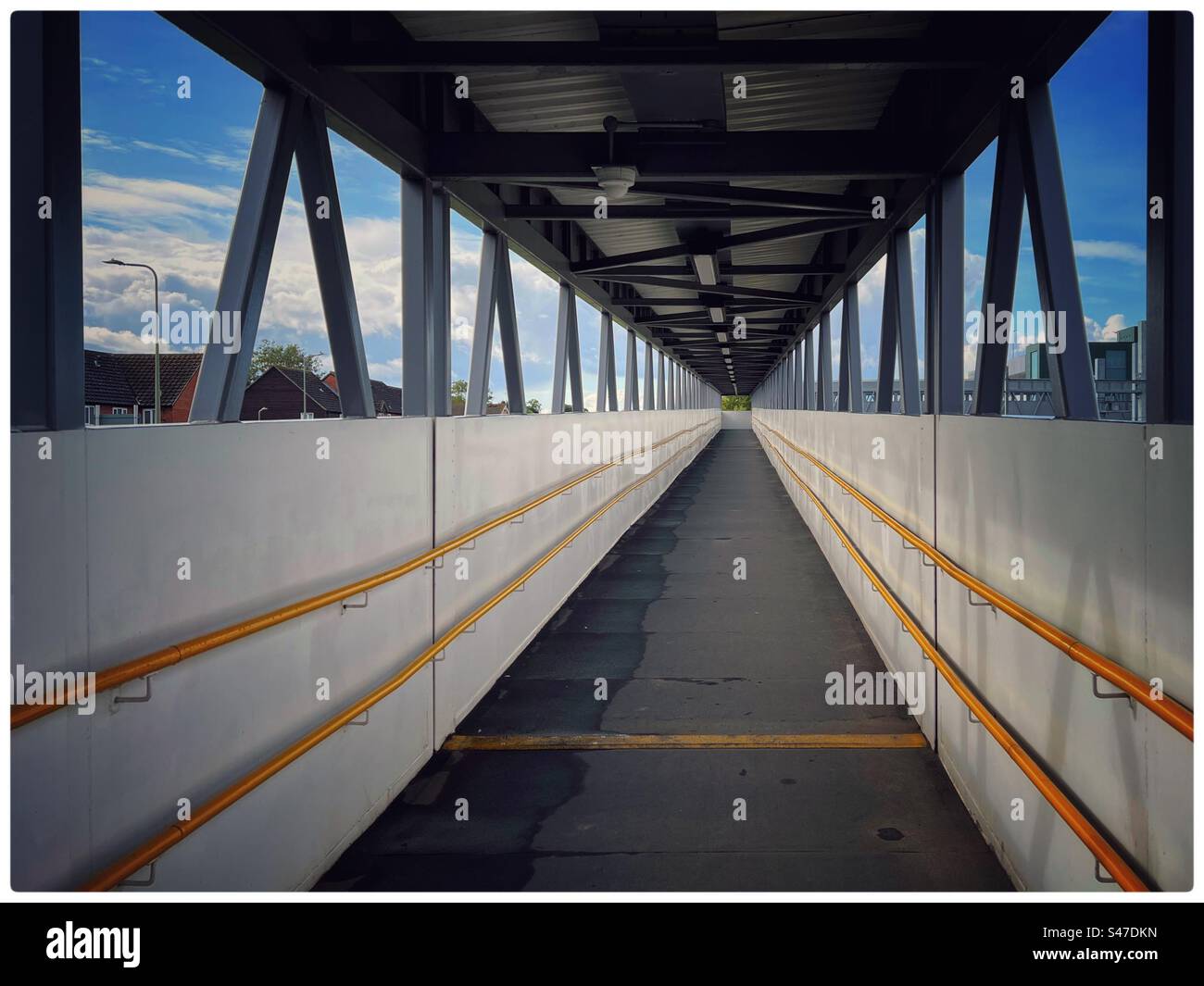 Modern pedestrian walkway with white walls and yellow handrails - Smartphone Captured Stock Image