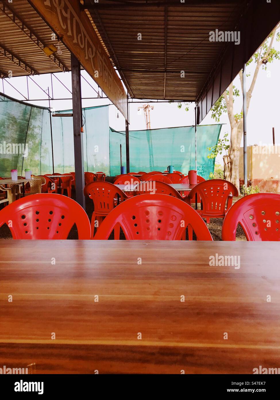 Red chairs at an eatery along a highway in India - Smartphone Captured Stock Image