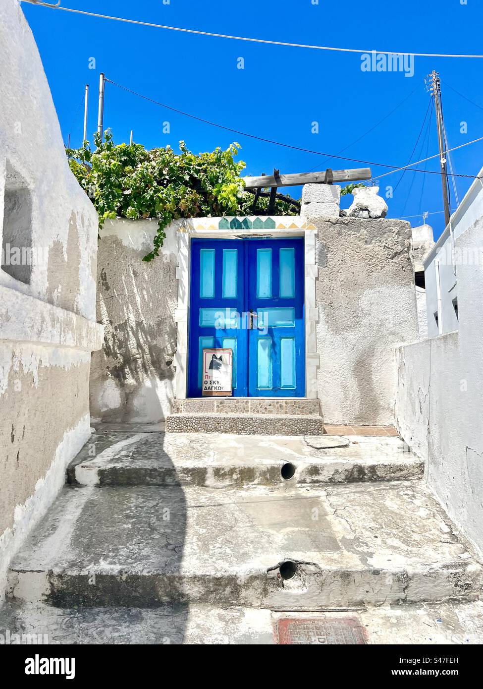 Two tone blue door on a whitewashed building, Santorini. - Smartphone Captured Stock Image