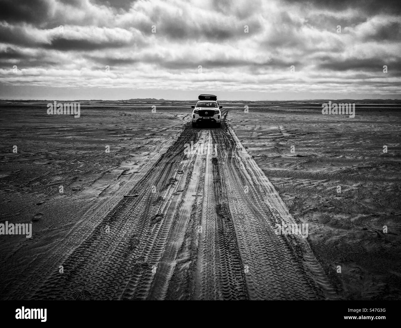 A 4x4 car drives on the sandy track in the Skeleton Coast in Namibia Stock Photo