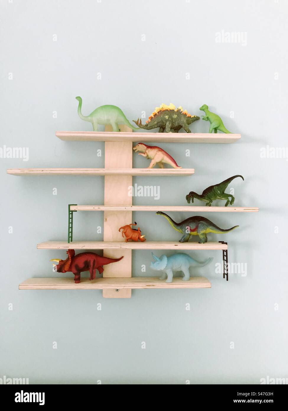 Dinosaur toys on display on shelves on the wall - Smartphone Captured Stock Image