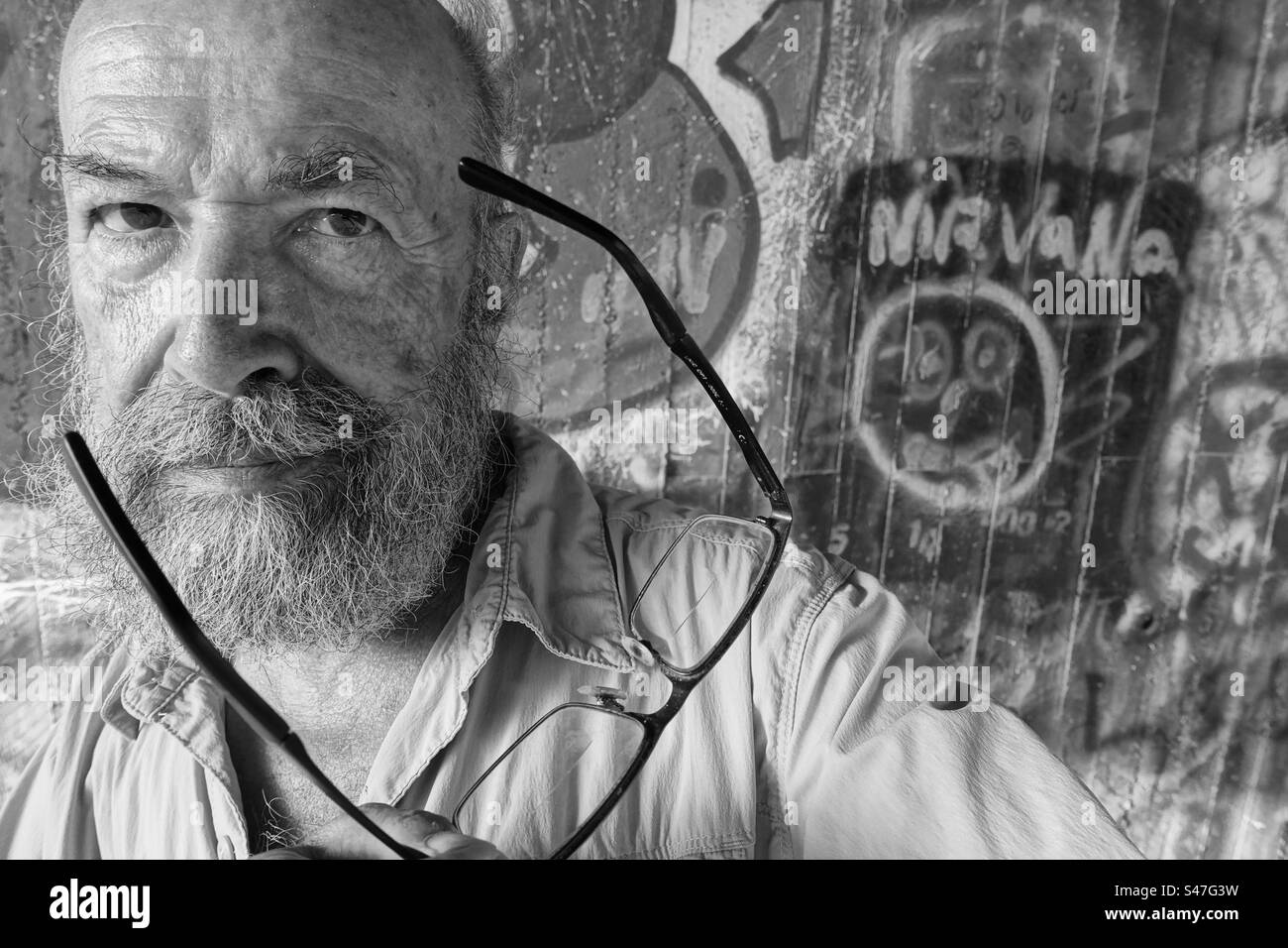 Monochrome Portrait of senior man against graffiti wall Stock Photo