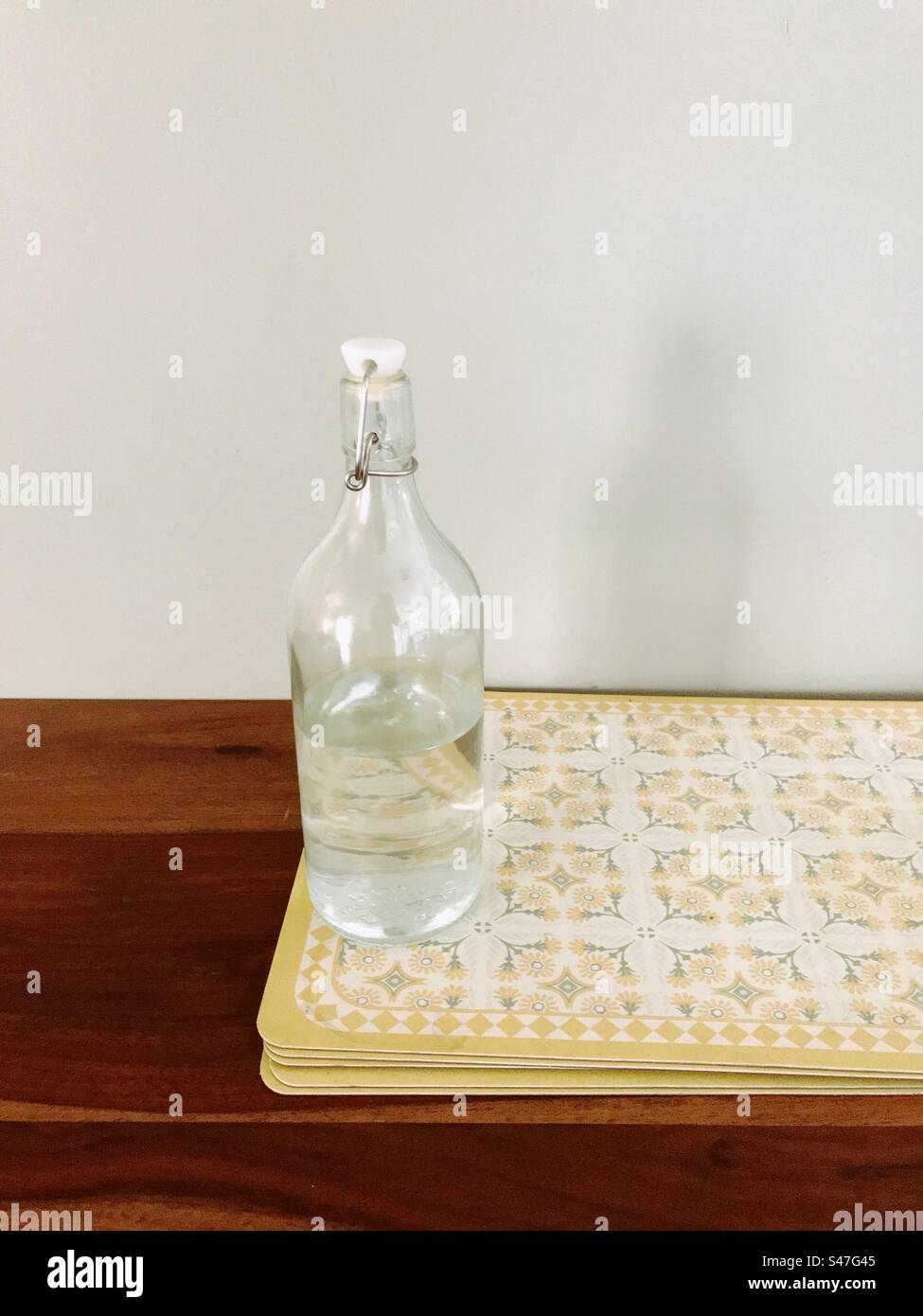 A transparent water bottle kept on a dining table - Smartphone Captured Stock Image