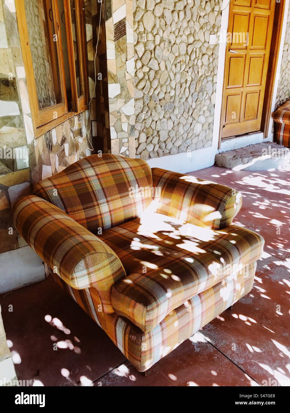 A sofa kept in a corridor in the winter sunshine - Smartphone Captured Stock Image