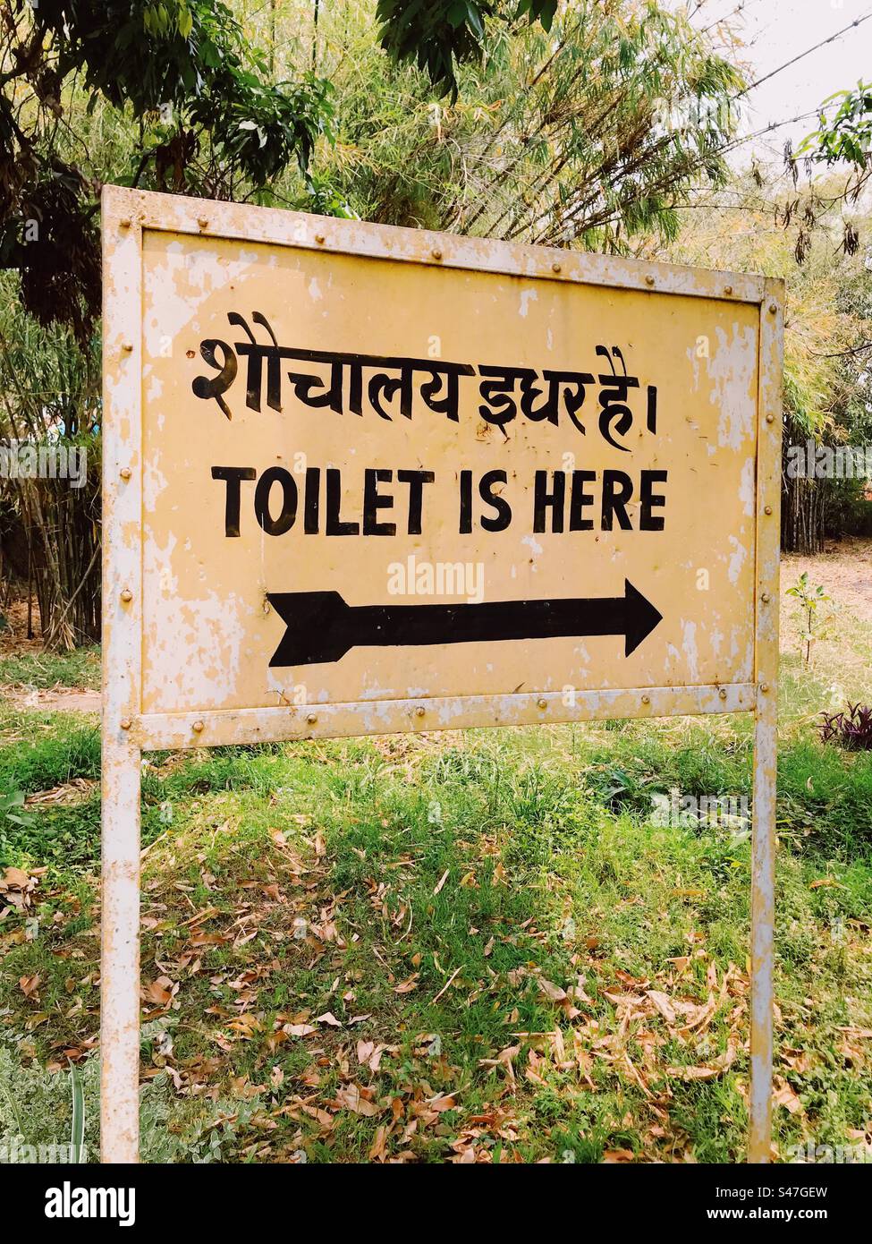 A sign with an arrow indicating where the toilet is - Smartphone Captured Stock Image