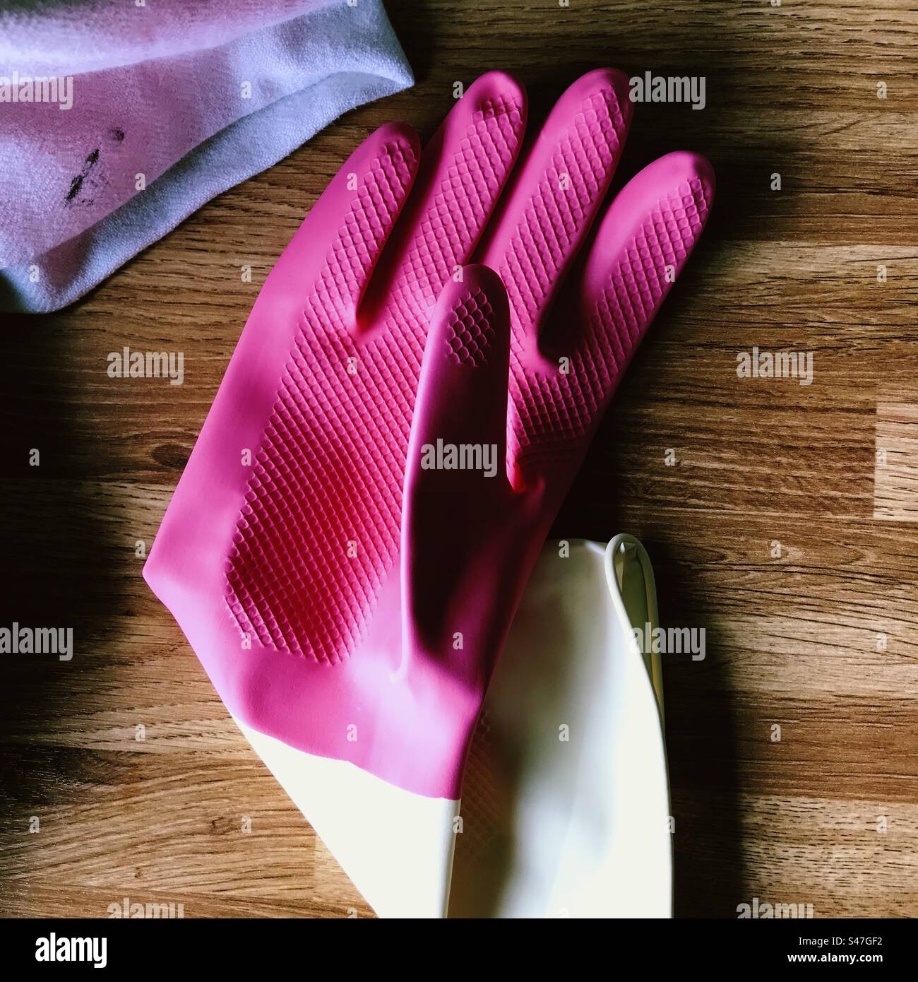 A pink latex glove on a table Stock Photo