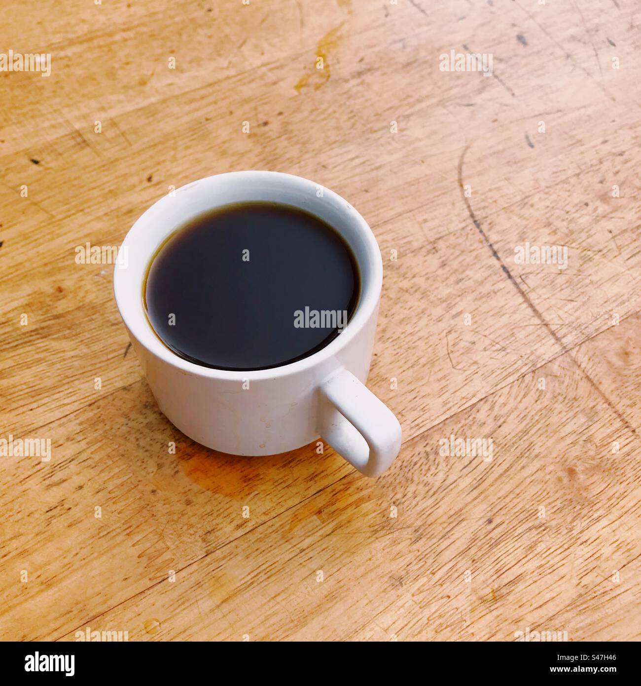 A cup of black coffee on a brown table - Smartphone Captured Stock Image