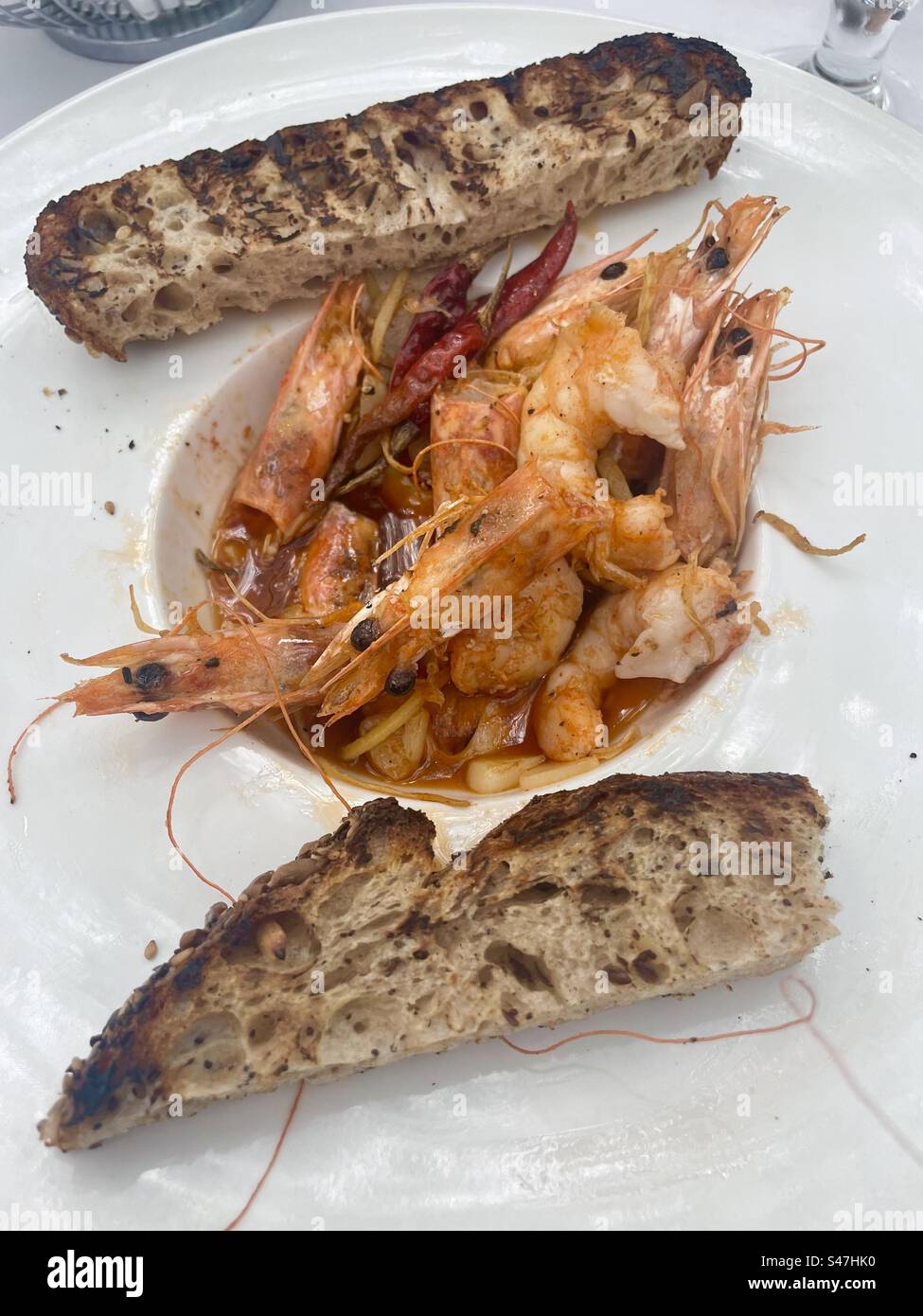 An appetizer plate of shrimp with heads and toast - Smartphone Captured Stock Image