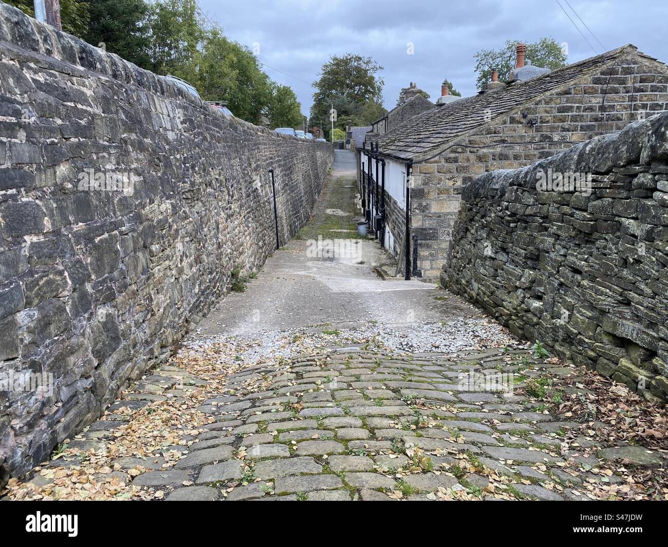 Narrow cobbled stone street, by Mill Bank Road, on a cloudy day near, Ripponden, Yorkshire, UK