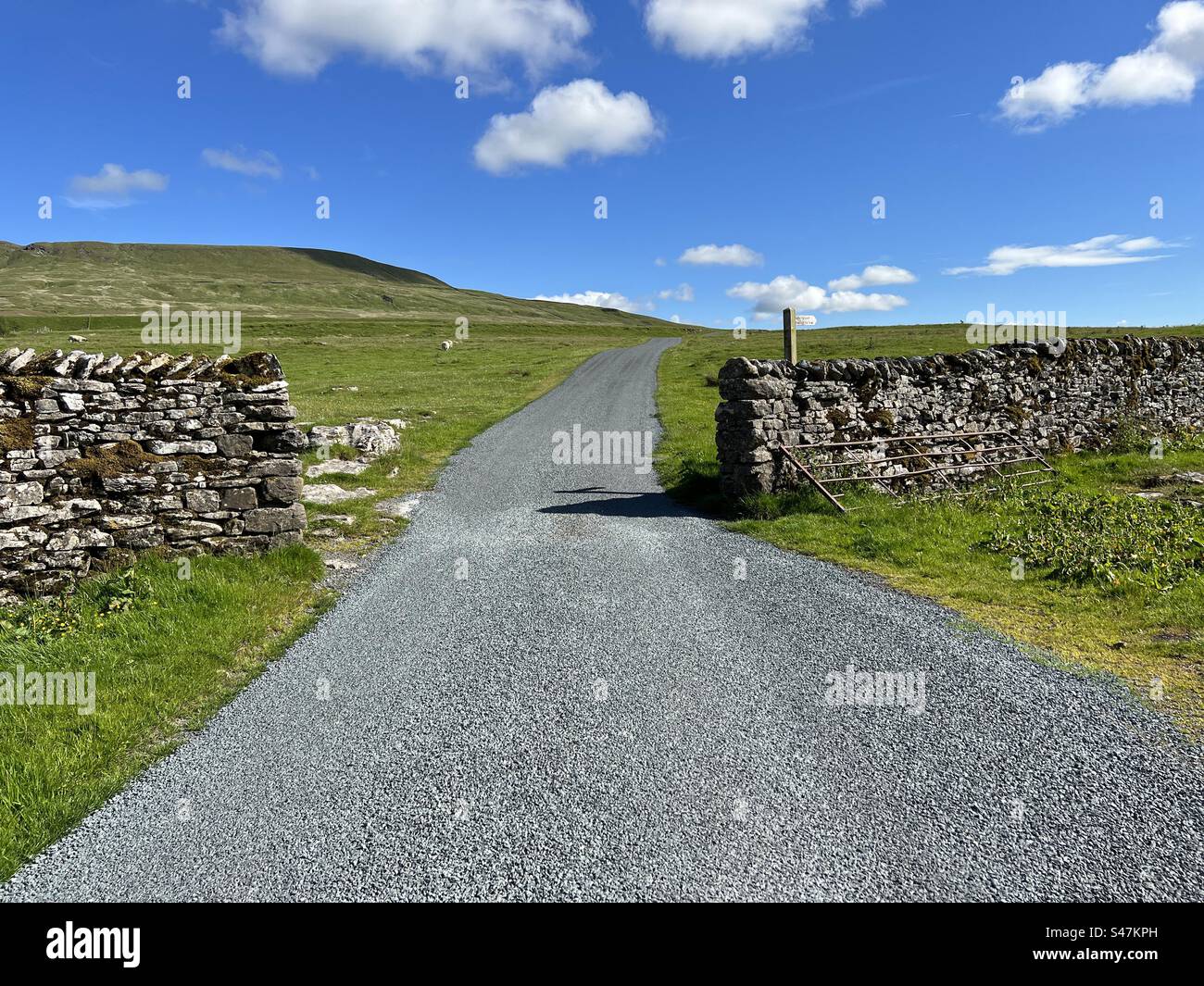 Yorkshire Dales moor top road, with, dry stone walls, distant hills, and a blue sky near, Halton Gill, Craven, U Stock Photo