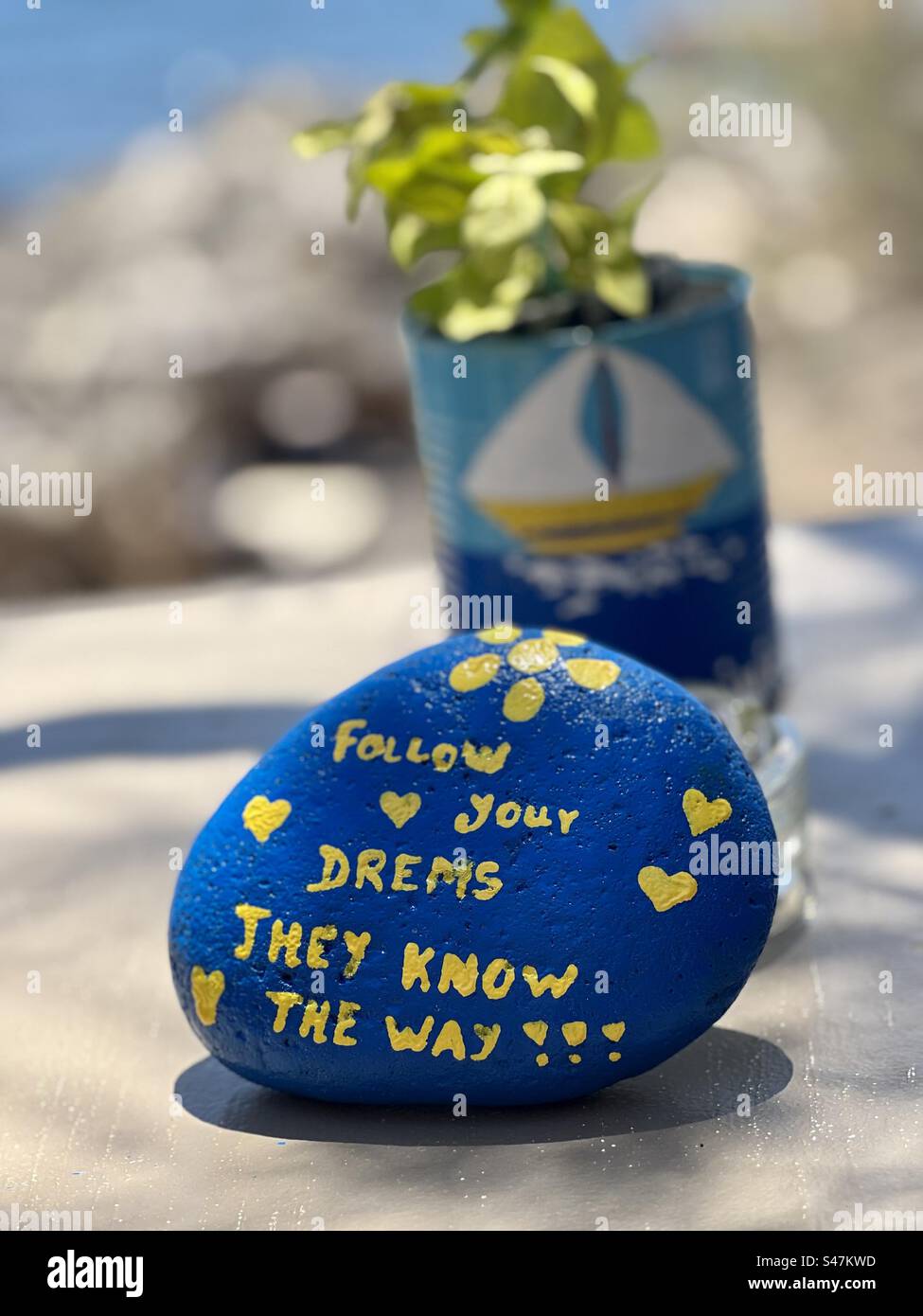 Despite a misspelling, this inspirational message to follow your dreams is good advice. Painted on a rock, Kaminia beach, Santorini. - Smartphone Captured Stock Image