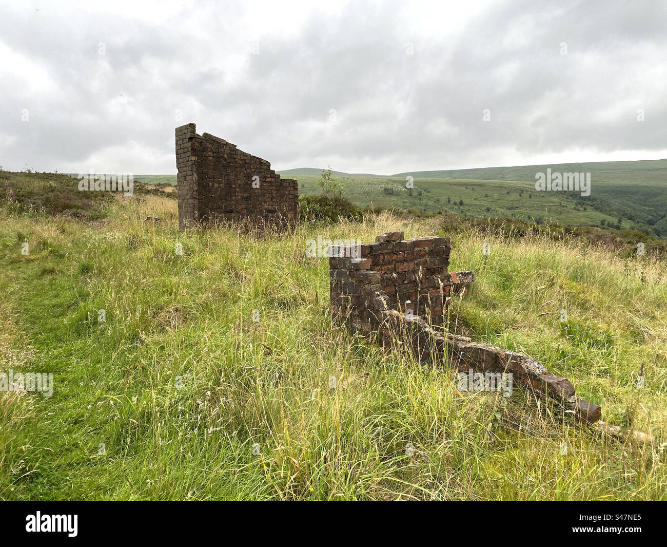 Old ruins, on the hills above, Butterley Reservoir, with wild grasses, wind and rain in, Marsden, Huddersfield, UK Stock Photo