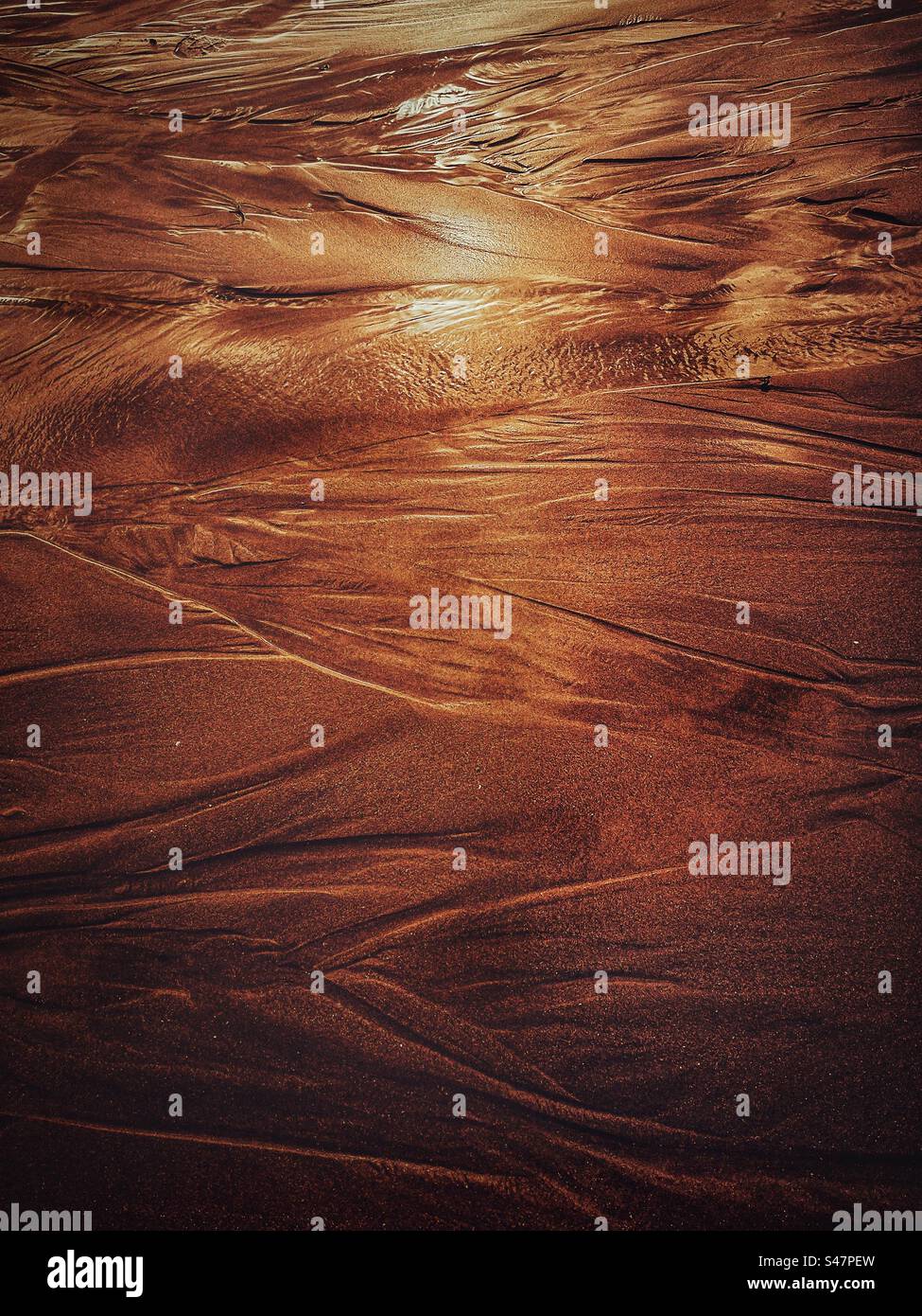 Sun reflecting on wet sand on the beach. - Smartphone Captured Stock Image
