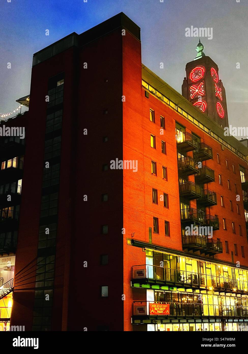 OXO tower and buildings in London at dusk with illuminated lights spelling OXO in red. A building that has a new life as an arts, entertainment and hospitality venue. - Smartphone Captured Stock Image