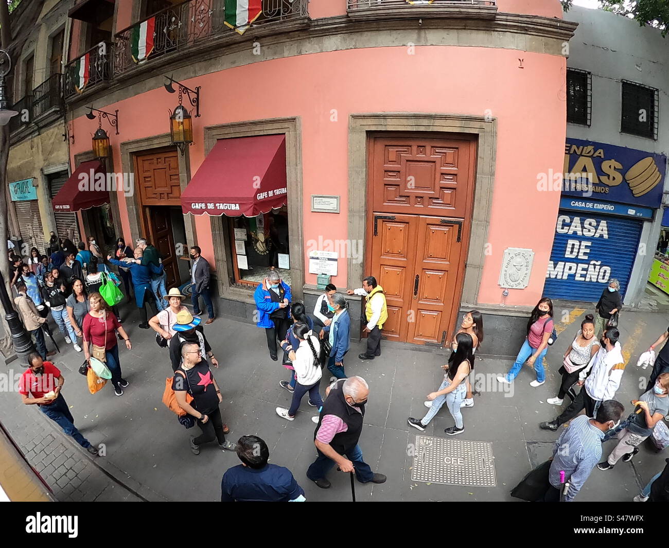 Pedestrians walking by the building painted pink in downtown Mexico City, 2022 - Smartphone Captured Stock Image