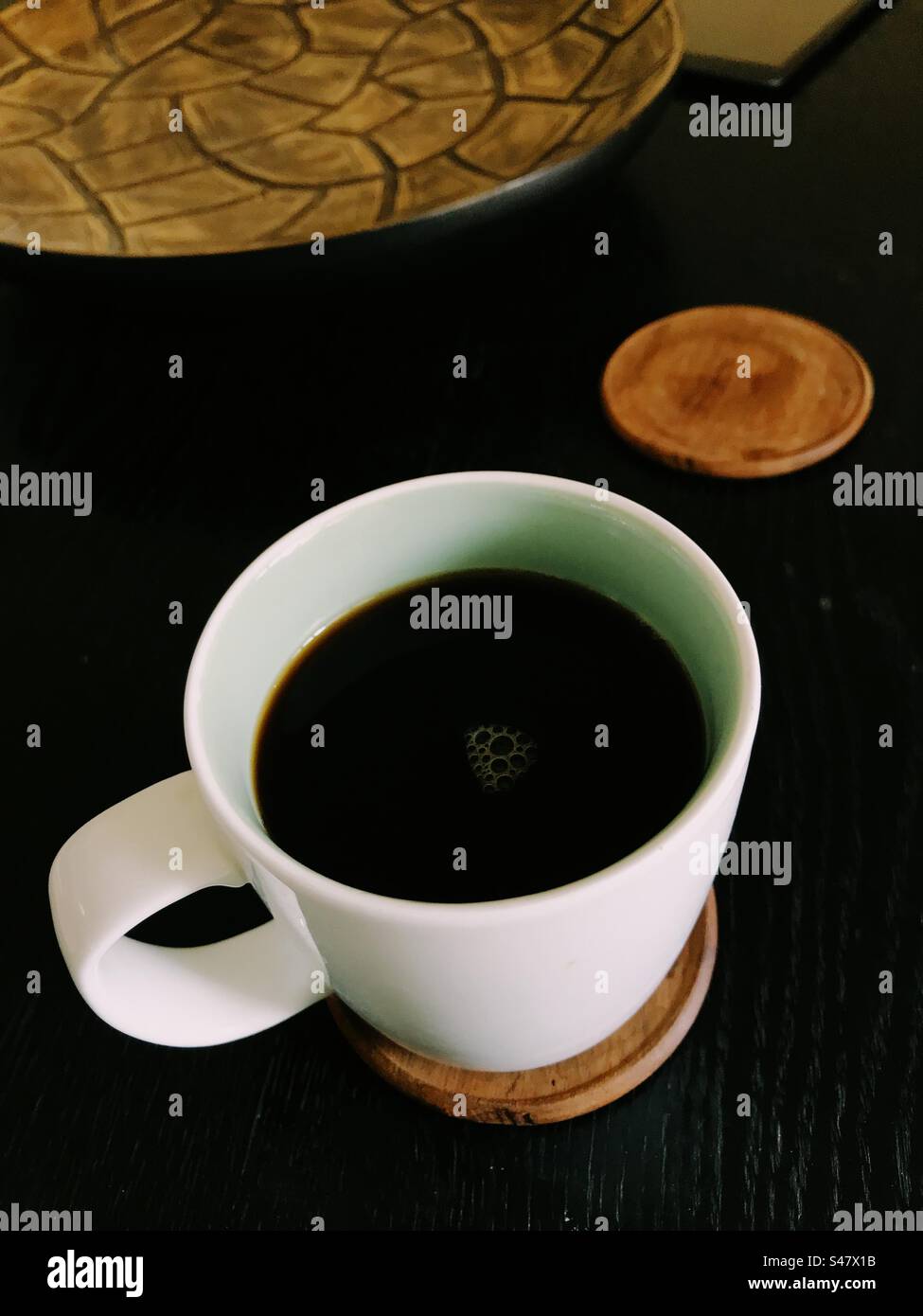 Black coffee in a mug on top of a table - Smartphone Captured Stock Image
