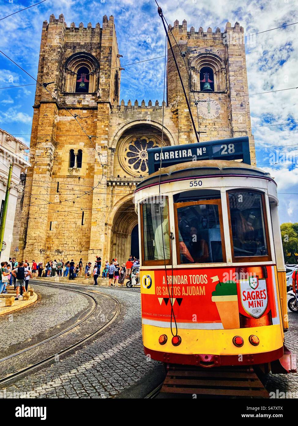 Number 28 tram passing the cathedral in Lisbon Portugal Stock Photo