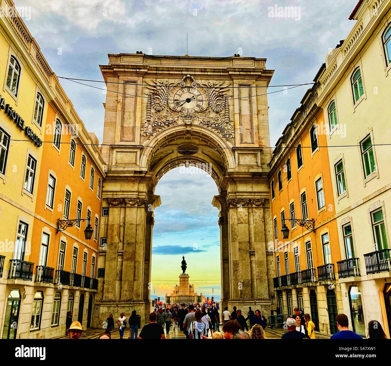 Walking through Arco da Rua Augusta archway in Lisbon Portugal at sunset looking towards Praça do Comércio - Smartphone Captured Stock Image