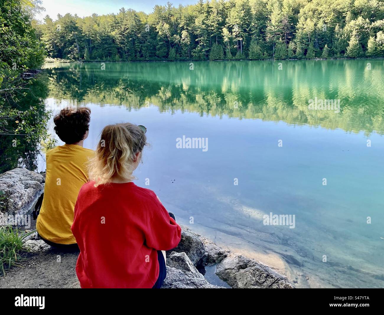 Taking a break hiking around the green water of Pink Lake in Gatineau Park. - Smartphone Captured Stock Image