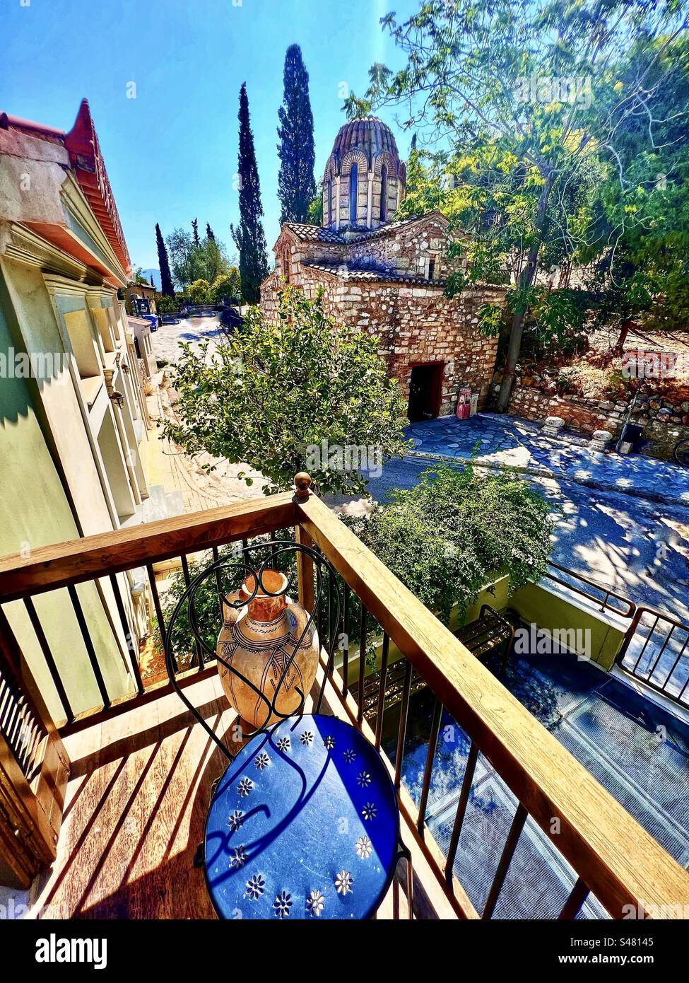 View from a quaint balcony in Plaka district of Athena, Greece with an old church on the street below - Smartphone Captured Stock Image