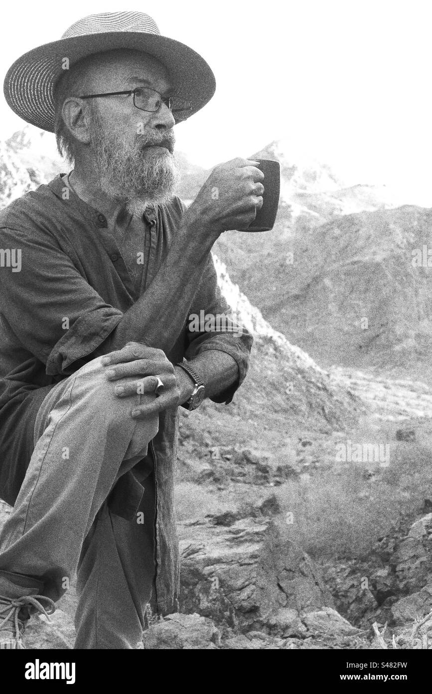 Senior man holding mug against mountains Stock Photo