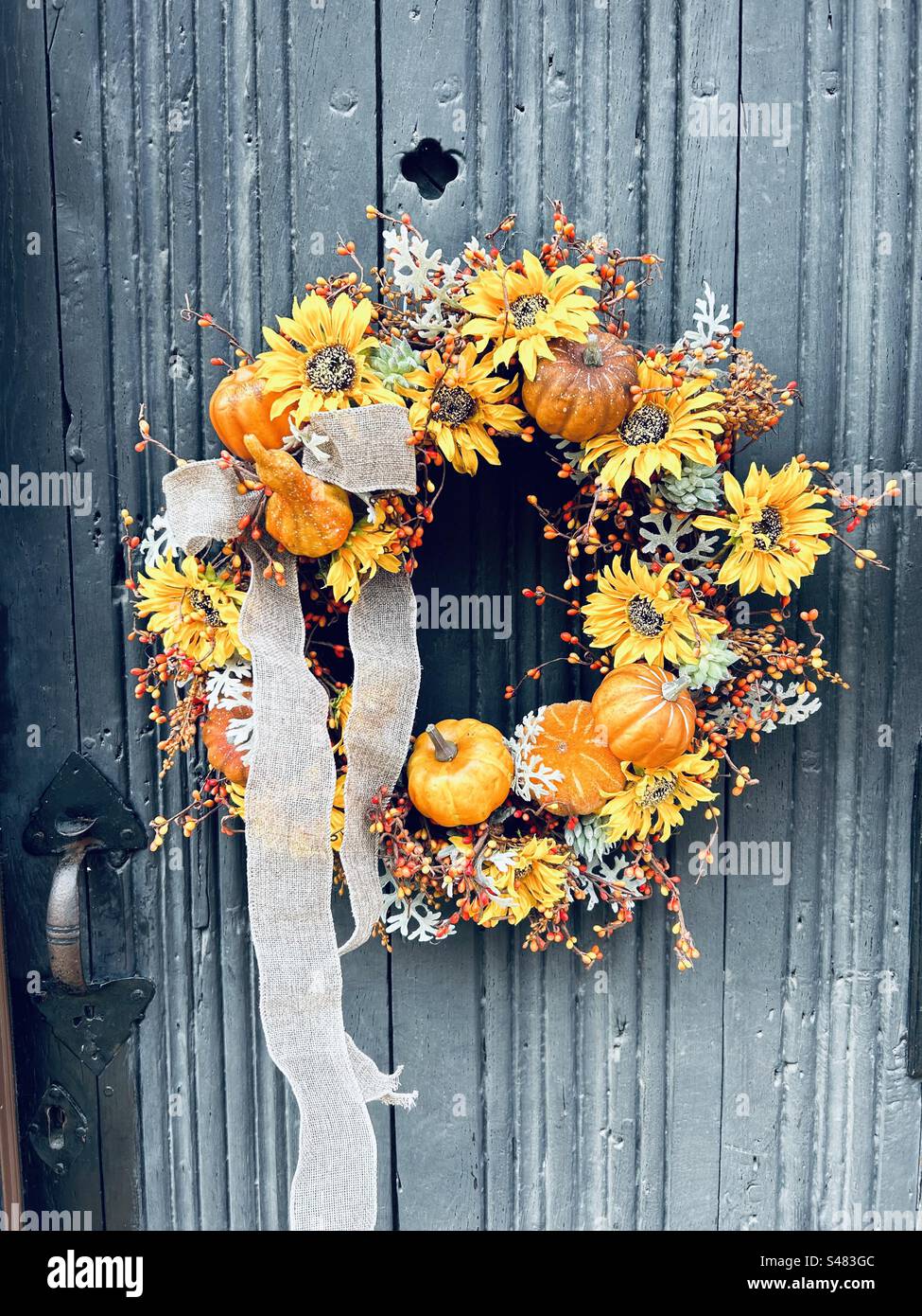 Halloween fall autumn orange wreath on medieval door in bury st edmunds - Smartphone Captured Stock Image