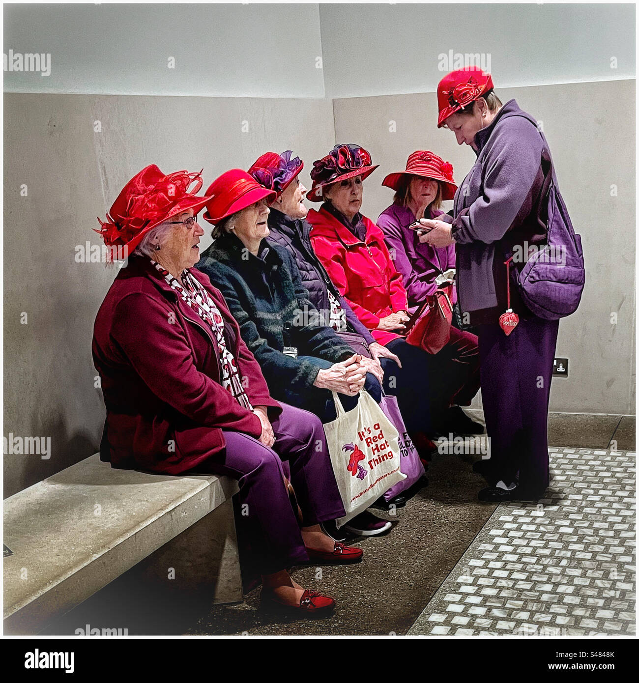 Ladies wearing red hats at the National Portrait Gallery, London Stock