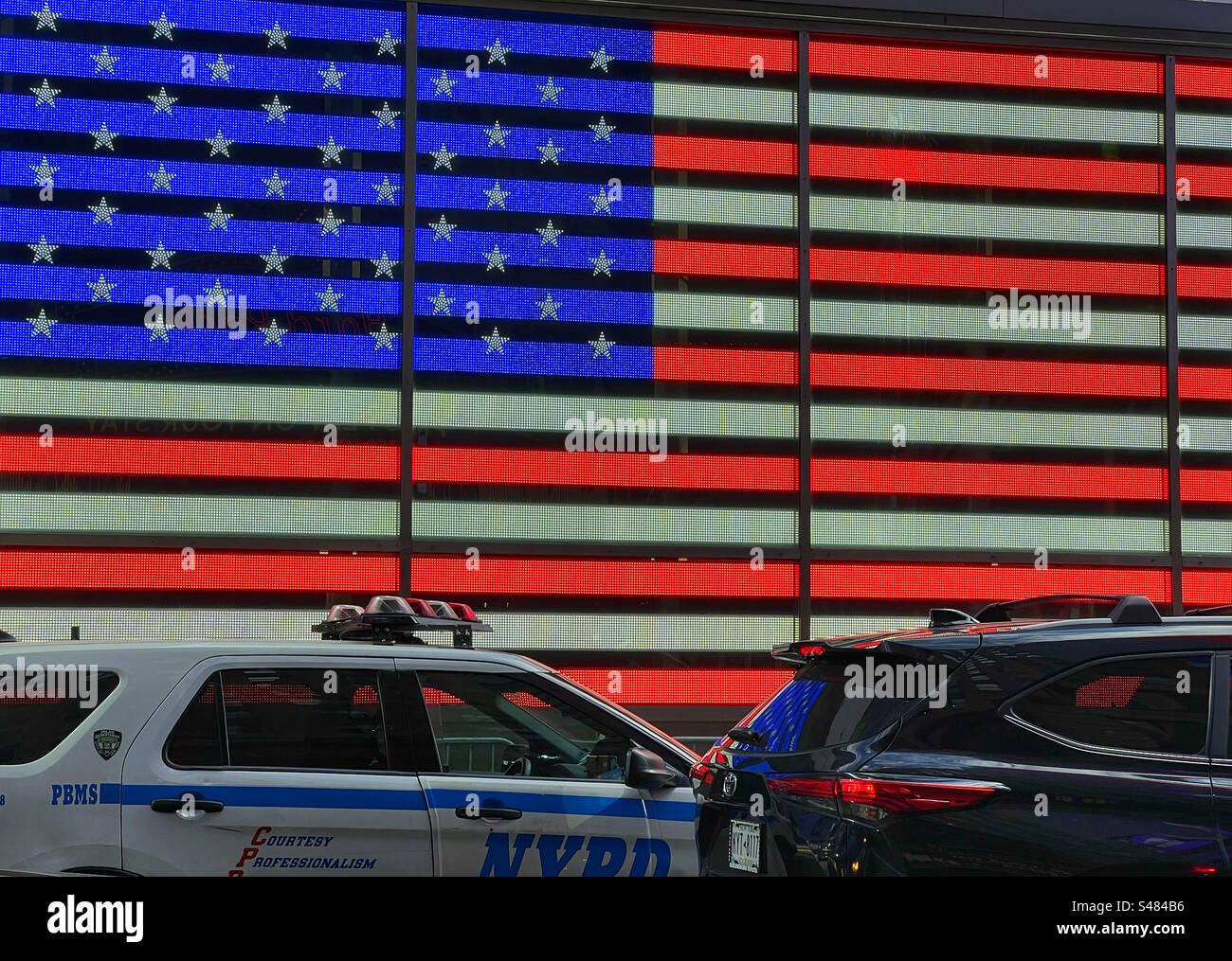 NYPD car in front of led US flag in Times Square New York City - Smartphone Captured Stock Image
