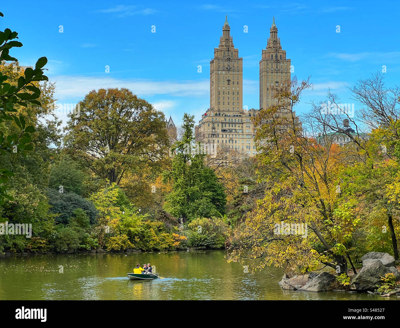 The San Remo building towers over lake in Central Park, New York - Smartphone Captured Stock Image