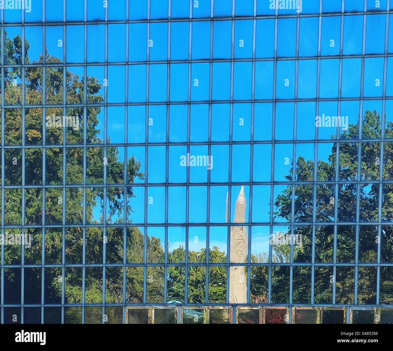 Cleopatras Needle in Central Park reflected in glass wall in rear of the Met in New York Stock Photo