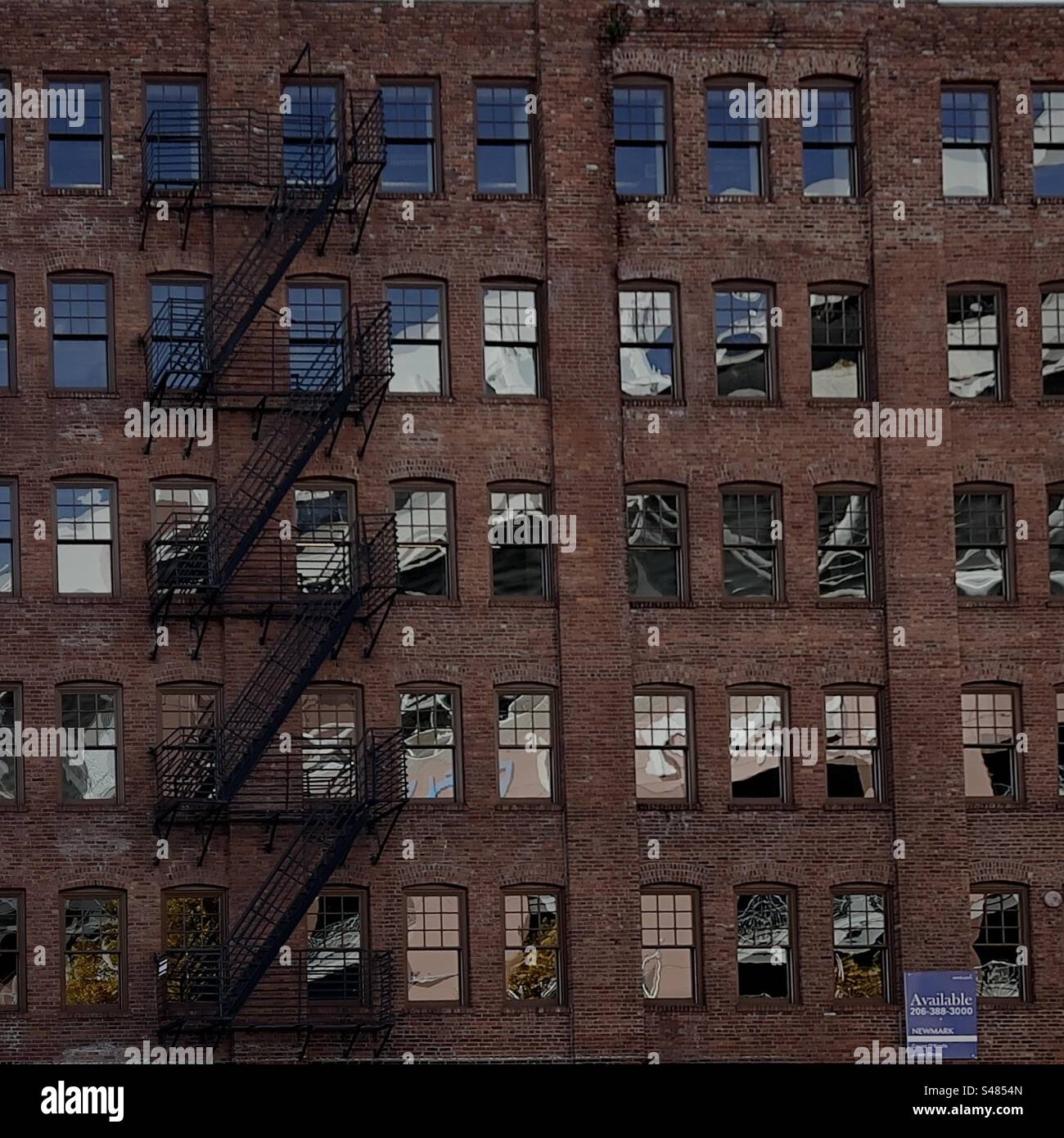 Réflection of football stadium in old brick building windows in Seattle’s Stadium District neighborhood. - Smartphone Captured Stock Image