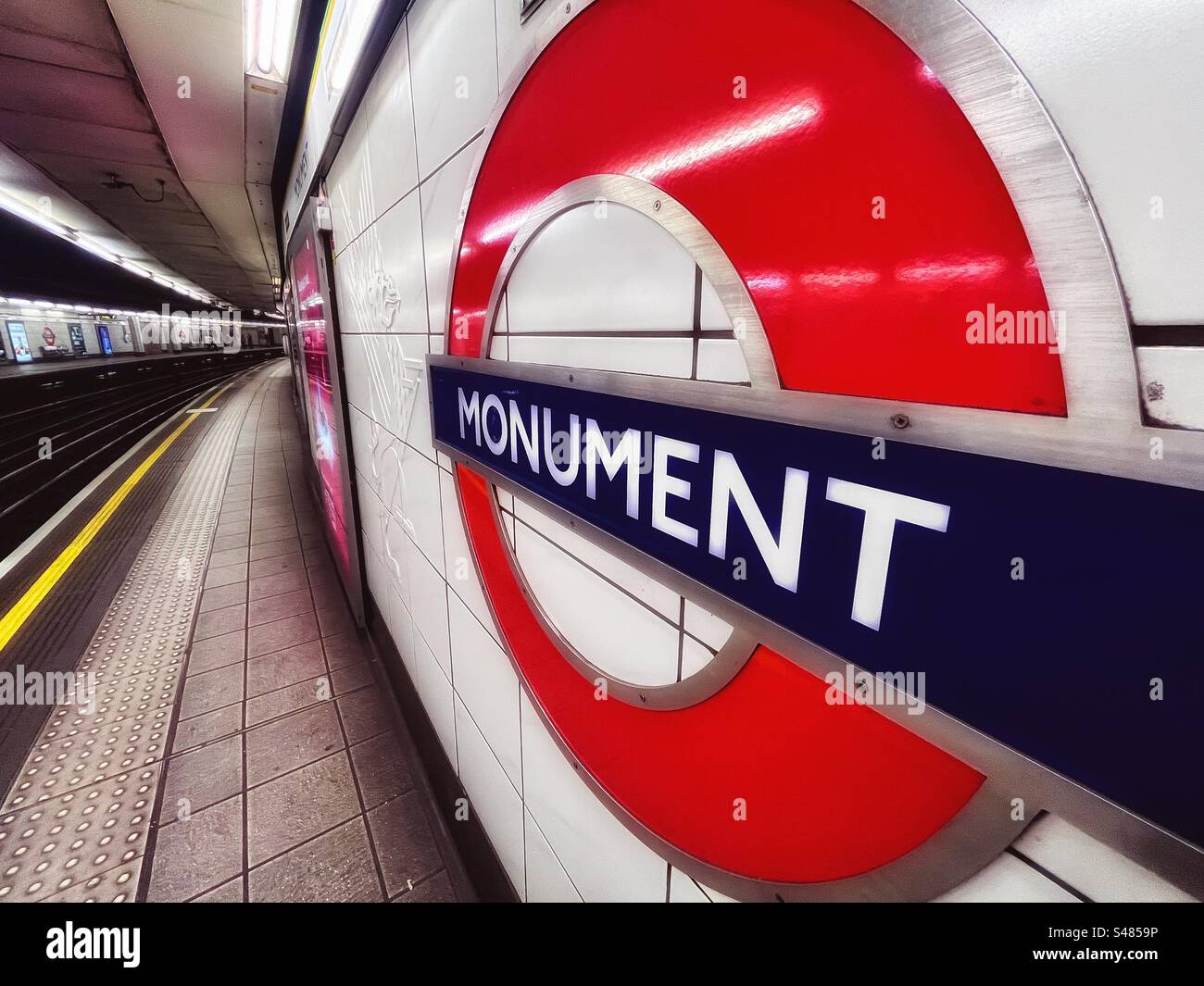 London Underground roundel sign says Monument- a station near the column commemorating the Great Fire of London in 1666. - Smartphone Captured Stock Image