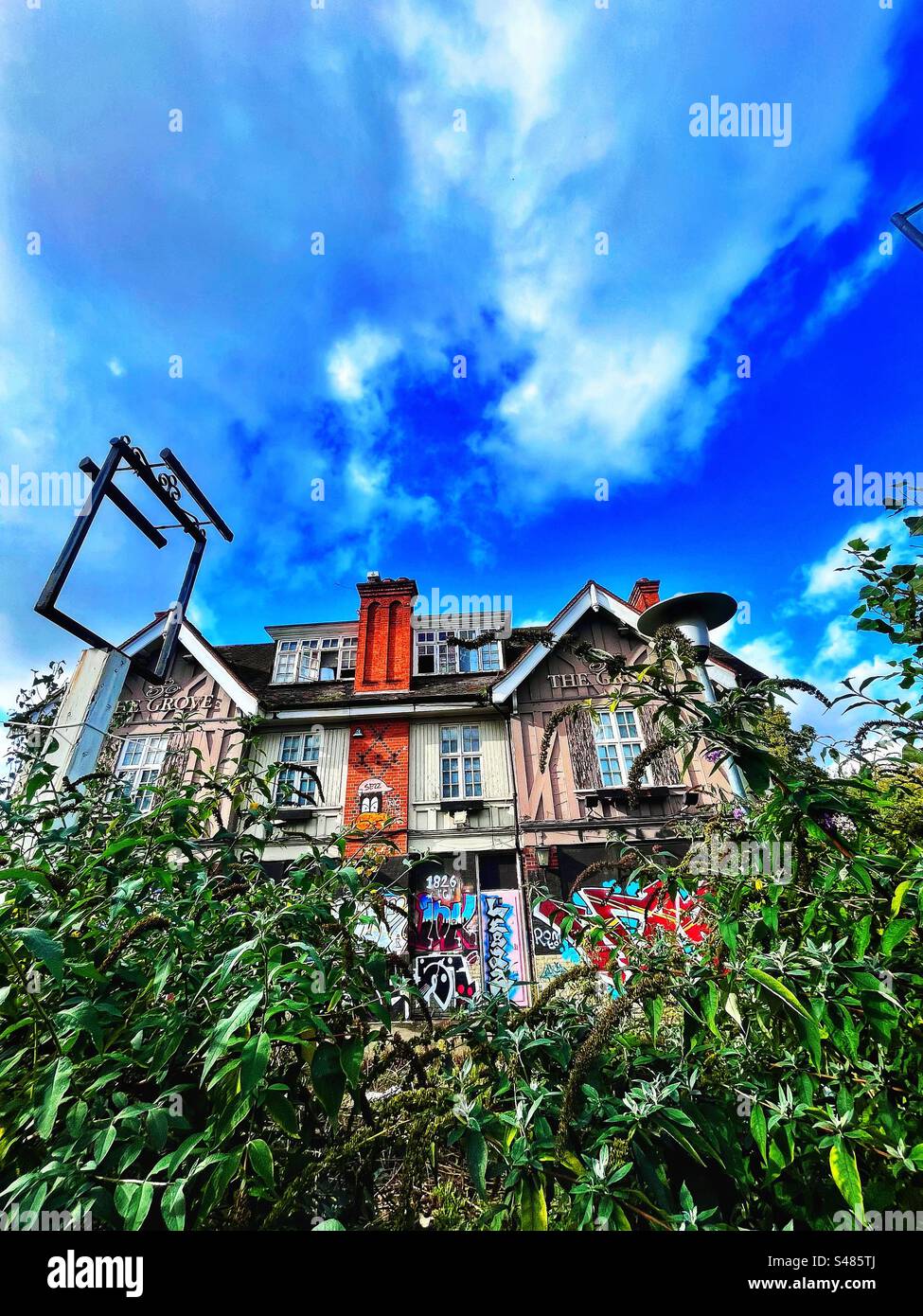 The Grove Tavern with empty sign in Lordship Lane, East Dulwich, London SE22. A pub or public house existed at this site for over 100 years. The building has graffiti and weeds growing around it Stock Photo