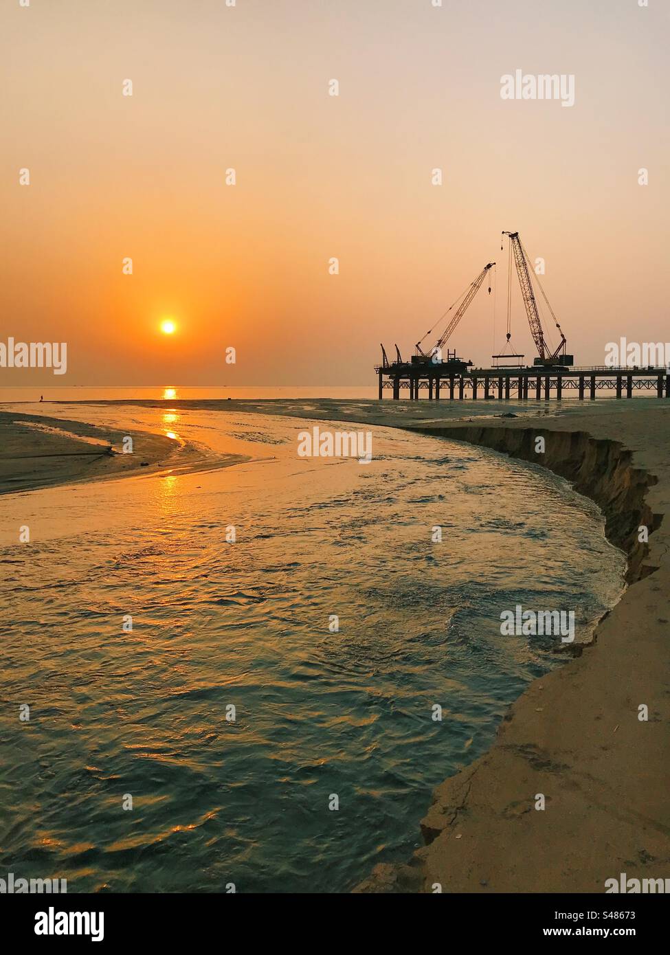 Construction of the coastal road on Versova Beach in Mumbai, India at sunset - Smartphone Captured Stock Image