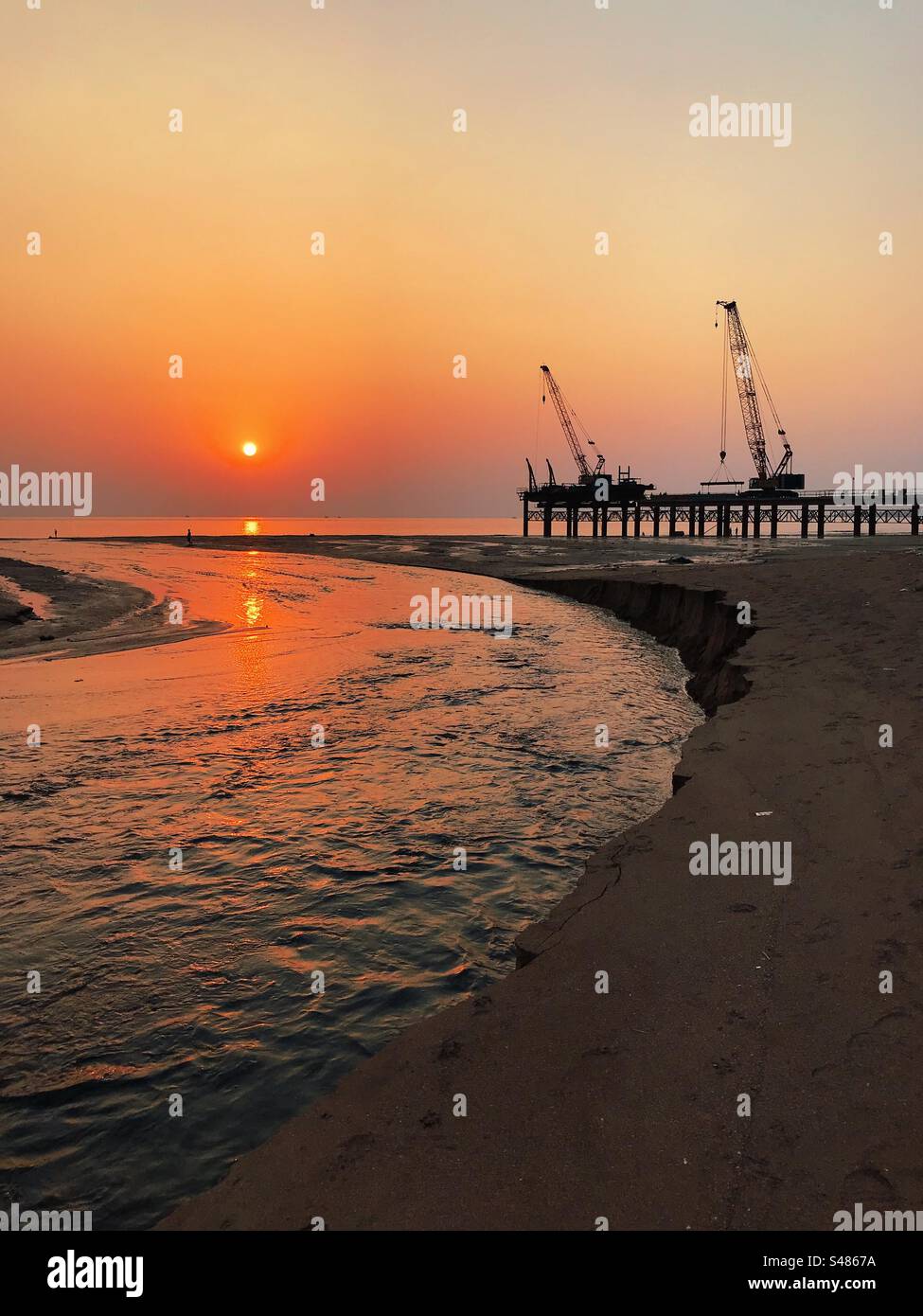 Construction of the coastal road on Versova Beach in Mumbai, India at sunset - Smartphone Captured Stock Image