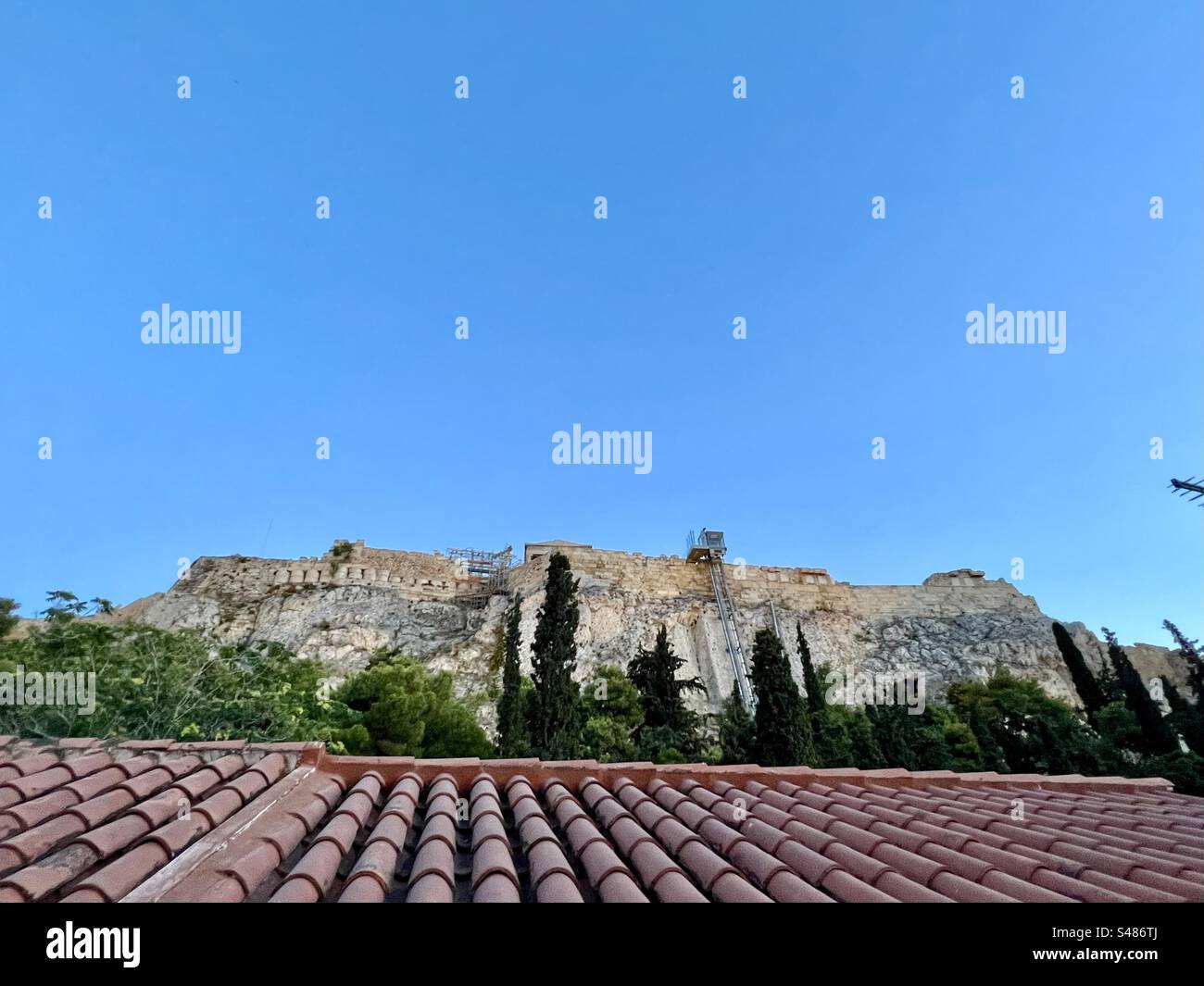 Looking over a rooftop in the Plaka district to the historical Acropolis hill in Athens - Smartphone Captured Stock Image