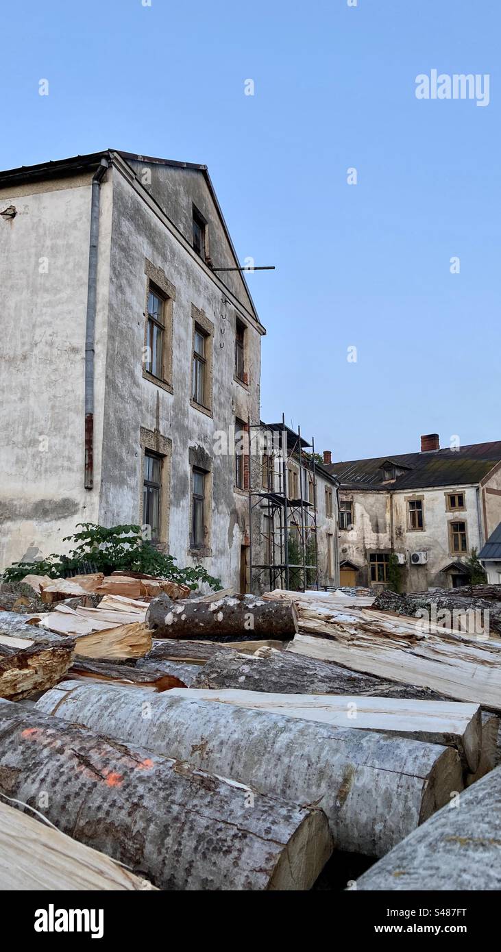 Firewood in foreground in front of an old house that is being renovated. - Smartphone Captured Stock Image