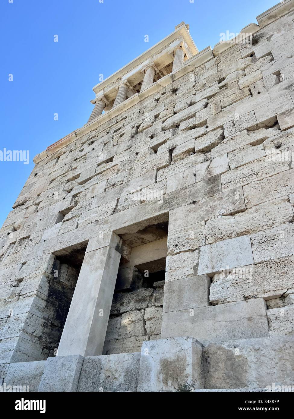 Looking up the marble stone facade to the Temple of Athena Nike in the Acropolis. - Smartphone Captured Stock Image