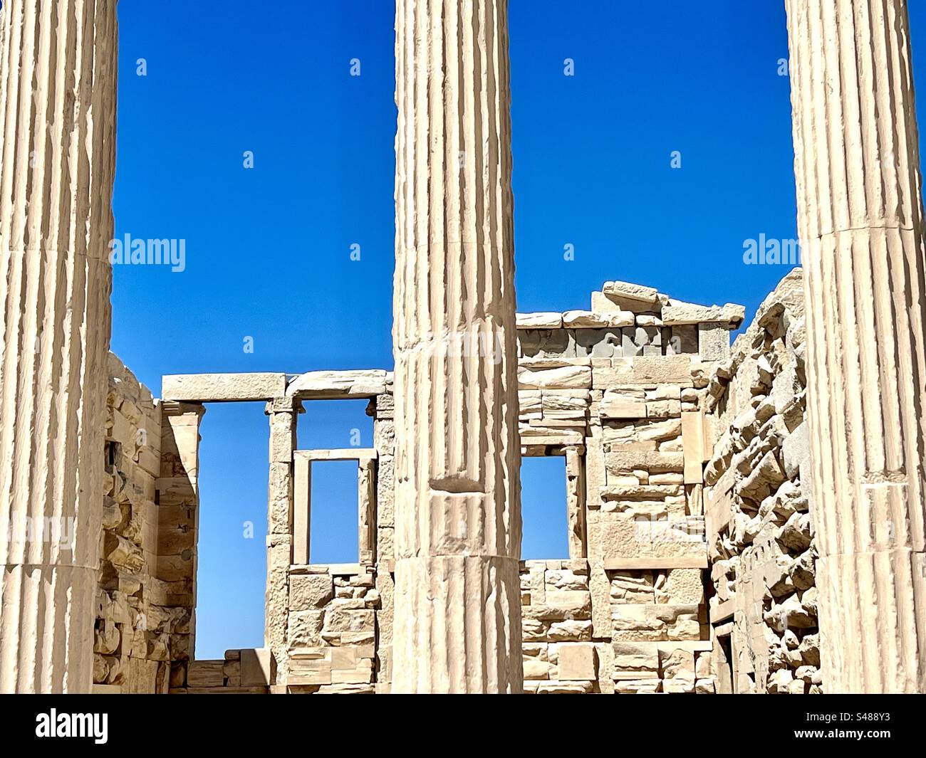 Tall marble columns and ruins of the acropolis against vibrant blue summer sky in Athens - Smartphone Captured Stock Image