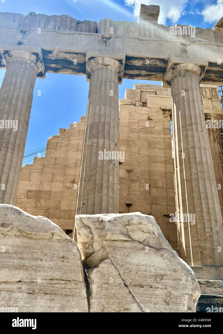 A ray of summer mid-day sun cuts down through the Acropolis ancient archeology site in Athens - Smartphone Captured Stock Image