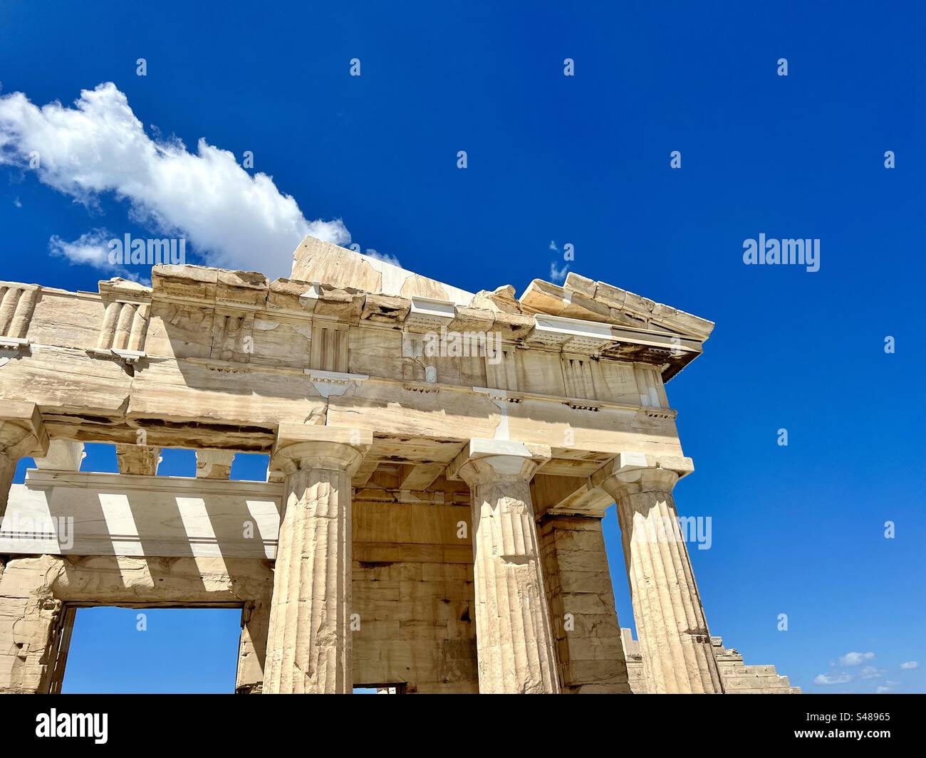 Corner frieze and columns against blue sky at The Paved Court of Klepsydra, Acropolis hill, Athens - Smartphone Captured Stock Image