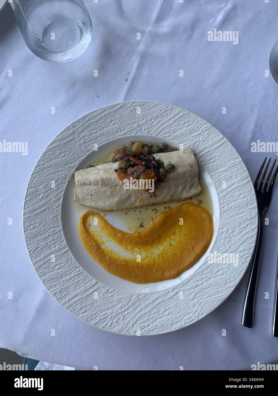 Panseared sea bass fillet with carrot mash and herbmarinated candied