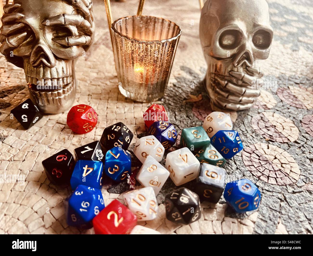 Role play dice with two skulls on a mosaic table - Smartphone Captured Stock Image